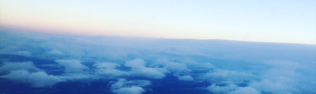 Bilde av en skyfull himmel tatt fra vinduet til et fly.