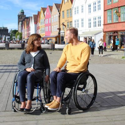 Bilde fra Brygga i Bergen. I fokus er Bergens varaordfører og nestleder i helse og sosialkomiteen, Marita Moltu, som prøver ut rullestol. Hun sitter ved siden av BPA-konsulent Lars Ivar Eilerås.