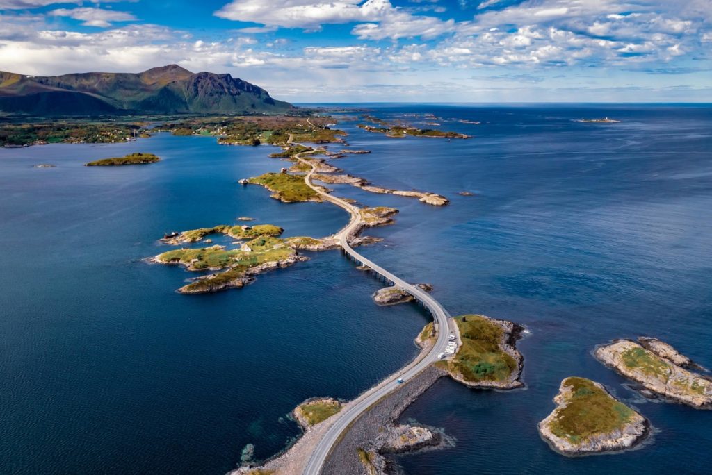 Bilde av atlanterhavsveien på Nordmøre. Man ser fjell i det fjerne og mørkeblått hav.