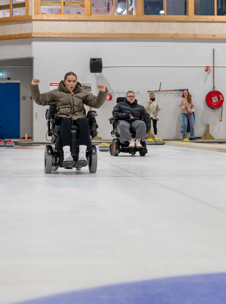 jente i rullestol spiller curling på isbane