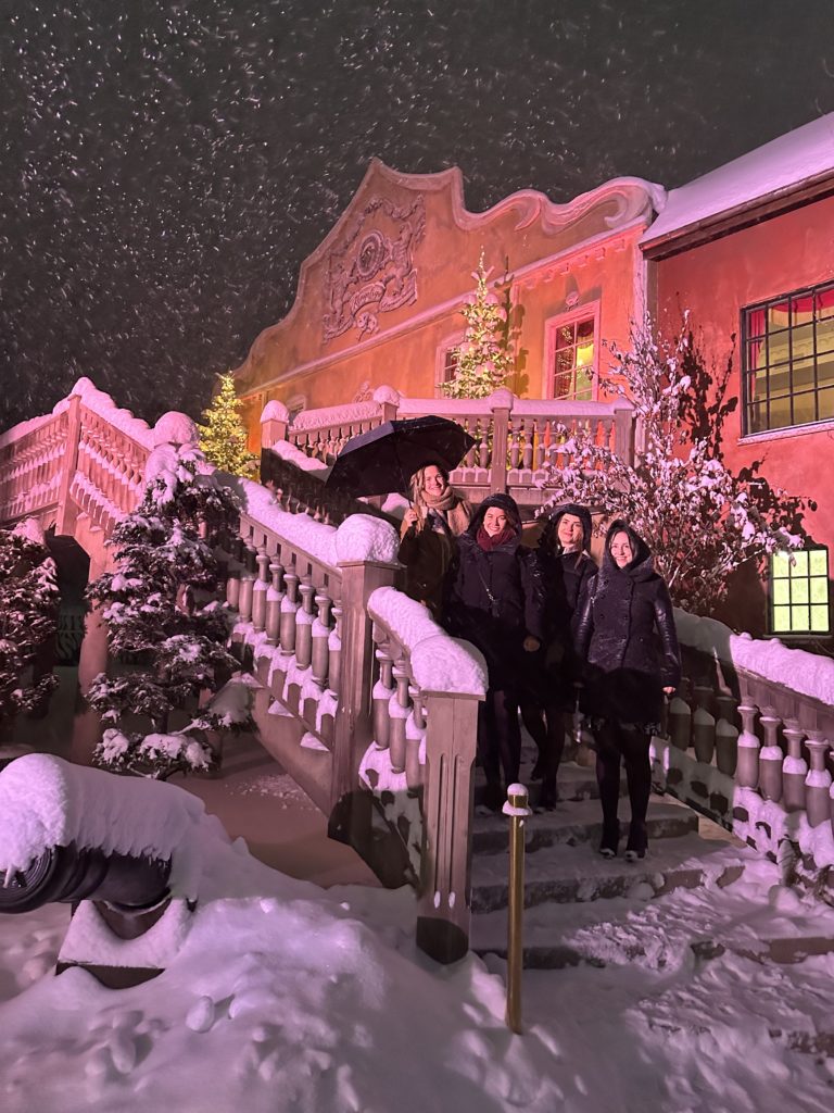 fire damer som står ute på en trapp mes det snør